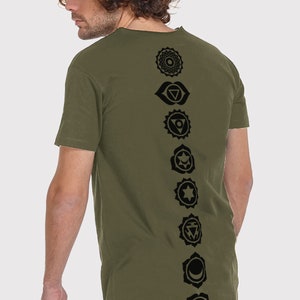 Pode incluir: Uma camiseta verde de manga comprida com uma fileira vertical de sete s&iacute;mbolos de chakras pretos impressos nas costas.