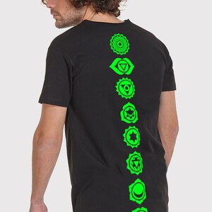 Pode incluir: Camiseta preta com uma estampa verde dos sete chakras nas costas.