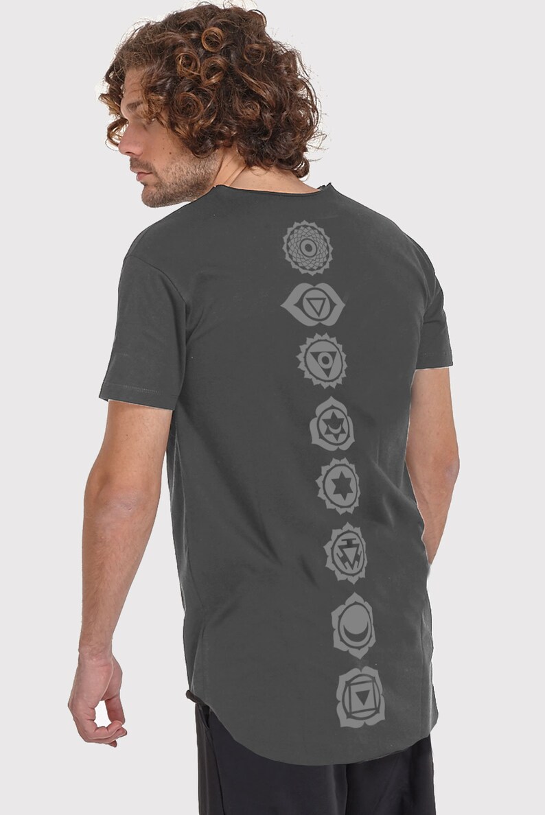 Pode incluir: Uma camiseta cinza-chumbo com uma fileira vertical de sete s&iacute;mbolos de chakras cinzentos impressos nas costas.