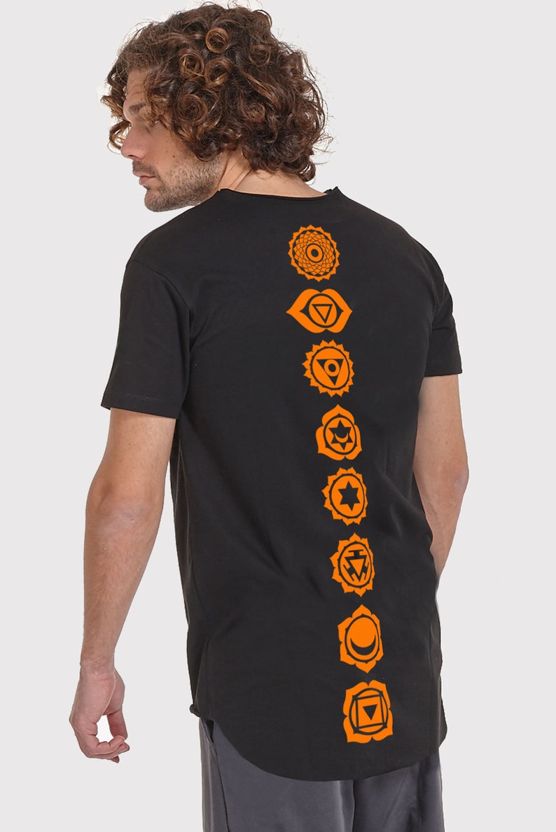 Pode incluir: Camiseta preta de manga comprida com um design laranja de sete chakras nas costas.