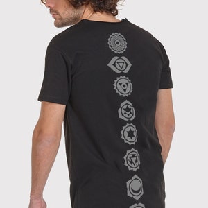 Pode incluir: Camiseta preta de manga comprida com uma fileira de sete s&iacute;mbolos de chakras cinzentos impressos nas costas.