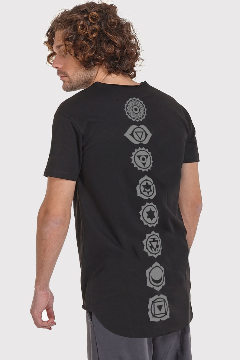 Pode incluir: Camiseta preta de manga comprida com uma fileira de sete s&iacute;mbolos de chakras cinzentos impressos nas costas.