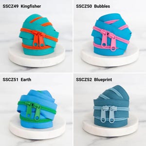 May include: Four coils of nylon zippers labeled SSCZ49 Kingfisher in teal and orange, SSCZ50 Bubbles in blue and pink, SSCZ51 Earth in light blue and green, and SSCZ52 Blueprint in dark blue, each featuring two matching zipper pulls.