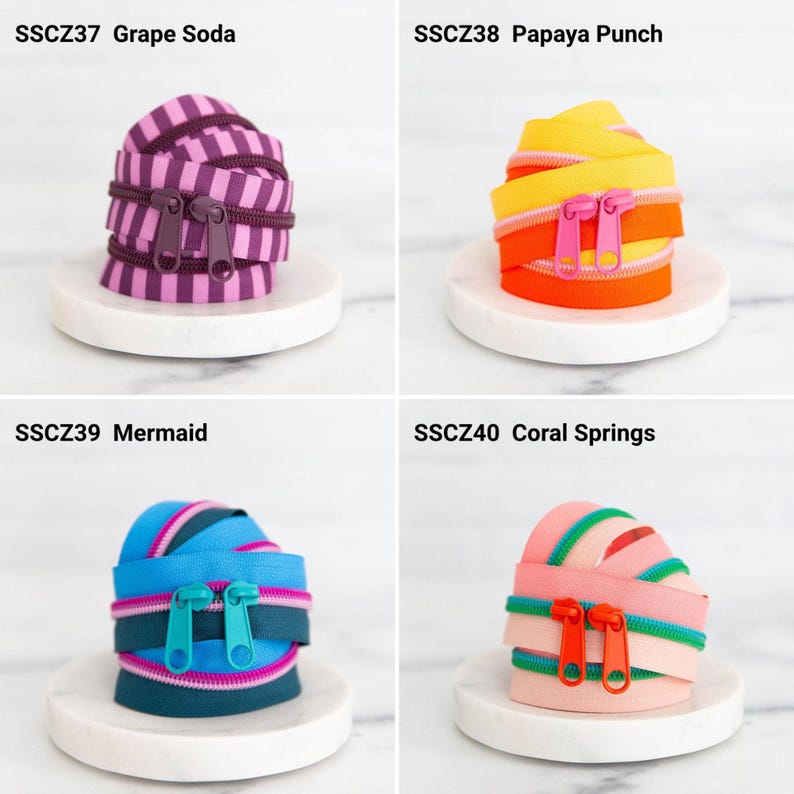 May include: Four coiled zippers labeled SSCZ37 Grape Soda with purple stripes, SSCZ38 Papaya Punch with yellow and orange, SSCZ39 Mermaid with blue and pink, and SSCZ40 Coral Springs with pink and green, each featuring two matching zipper pulls.