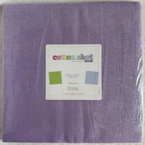 May include: A purple cotton fabric with a label that reads "cotton shot by Amanda Murphy PEARL (42) 10"x 10" pieces 100% Cotton benartex.com Benartex CUT AND ASSEMBLED IN THE USA"