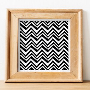 May include: A framed black and white print with a chevron pattern. The frame is made of light wood.