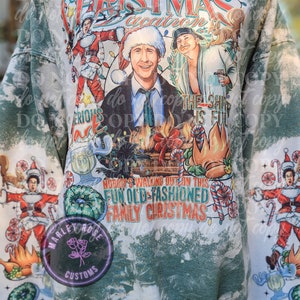 May include: A green and white Christmas-themed sweatshirt with a graphic featuring characters and text from the movie "Christmas Vacation." The design includes the text "Christmas Vacation" and "Nobody's Walking Out on This Fun Old-Fashioned Family Christmas."