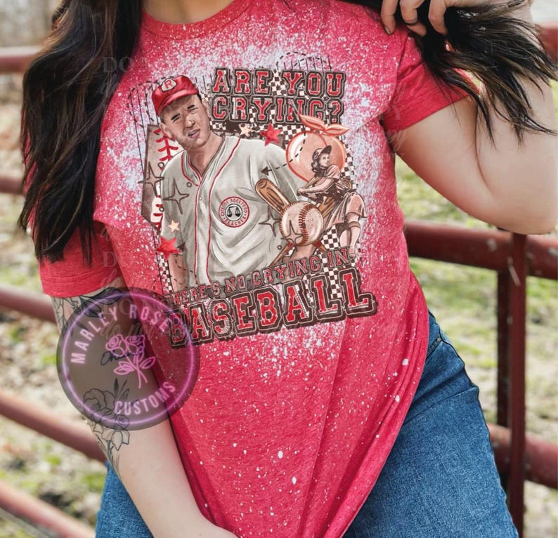 May include: Red, white, and blue bleached t-shirt with a baseball player graphic and the text "Are you crying? There's no crying in baseball."