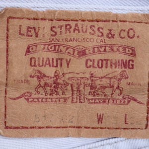 May include: A brown leather Levi Strauss & Co. patch with red text. The text reads "Original riveted quality clothing" and "Trade Mark Patented May 20 1873".