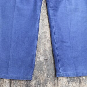 May include: A pair of blue denim trousers with a straight leg and a classic fit.