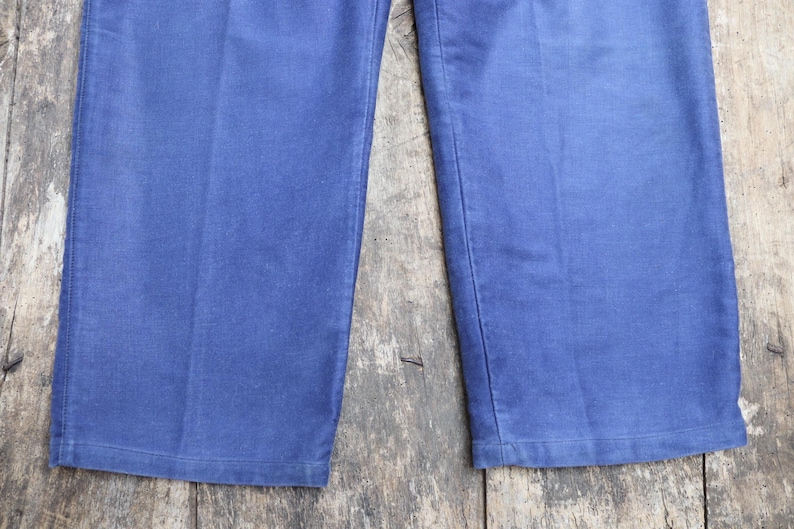 May include: A pair of blue denim trousers with a straight leg and a classic fit.