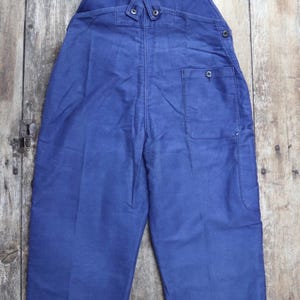 May include: A pair of blue denim dungarees with adjustable straps and a single back pocket.