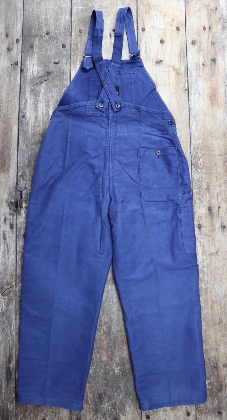 May include: A pair of blue denim dungarees with adjustable straps and a single back pocket.