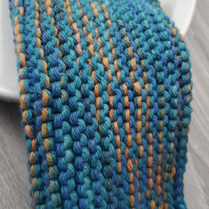 May include: A blue and orange knitted dishcloth with a textured surface.