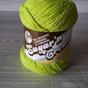 May include: A skein of bright green yarn labeled "The Original Sugar'n Cream" yarn.