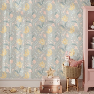 A child's room with pastel floral wallpaper, wooden toys on the floor, and a pink shelf with storage boxes