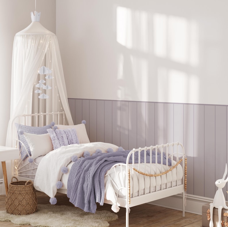May include: A white metal bed frame with a white and purple bedding set. The bed has a white canopy with a light string of lights. There is a purple throw blanket on the bed and a wicker basket on the floor next to the bed.
