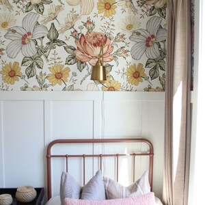 Puede incluir: Un dormitorio con papel tapiz blanco y floral, una estructura de cama de cobre y una almohada de tiro rosa. La habitaci&oacute;n tiene un z&oacute;calo blanco y una ventana con cortinas beige.