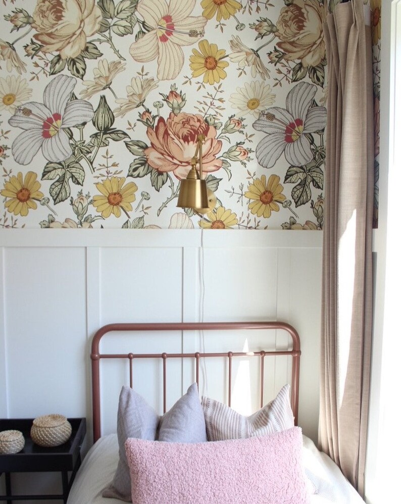Puede incluir: Un dormitorio con papel tapiz blanco y floral, una estructura de cama de cobre y una almohada de tiro rosa. La habitaci&oacute;n tiene un z&oacute;calo blanco y una ventana con cortinas beige.