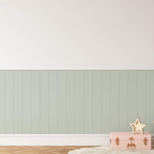 May include: A light green wood panel wall with a pink vintage suitcase, a wicker basket with fabric inside, and a gold star decoration. A cluster of pastel pink, white, and light blue balloons are tied together and floating in the upper right corner of the image.