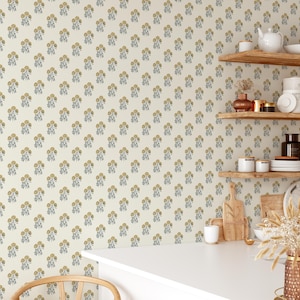 May include: A white wall with a repeating pattern of small yellow and blue floral designs. The wall is in a kitchen with wooden shelves and a white countertop.