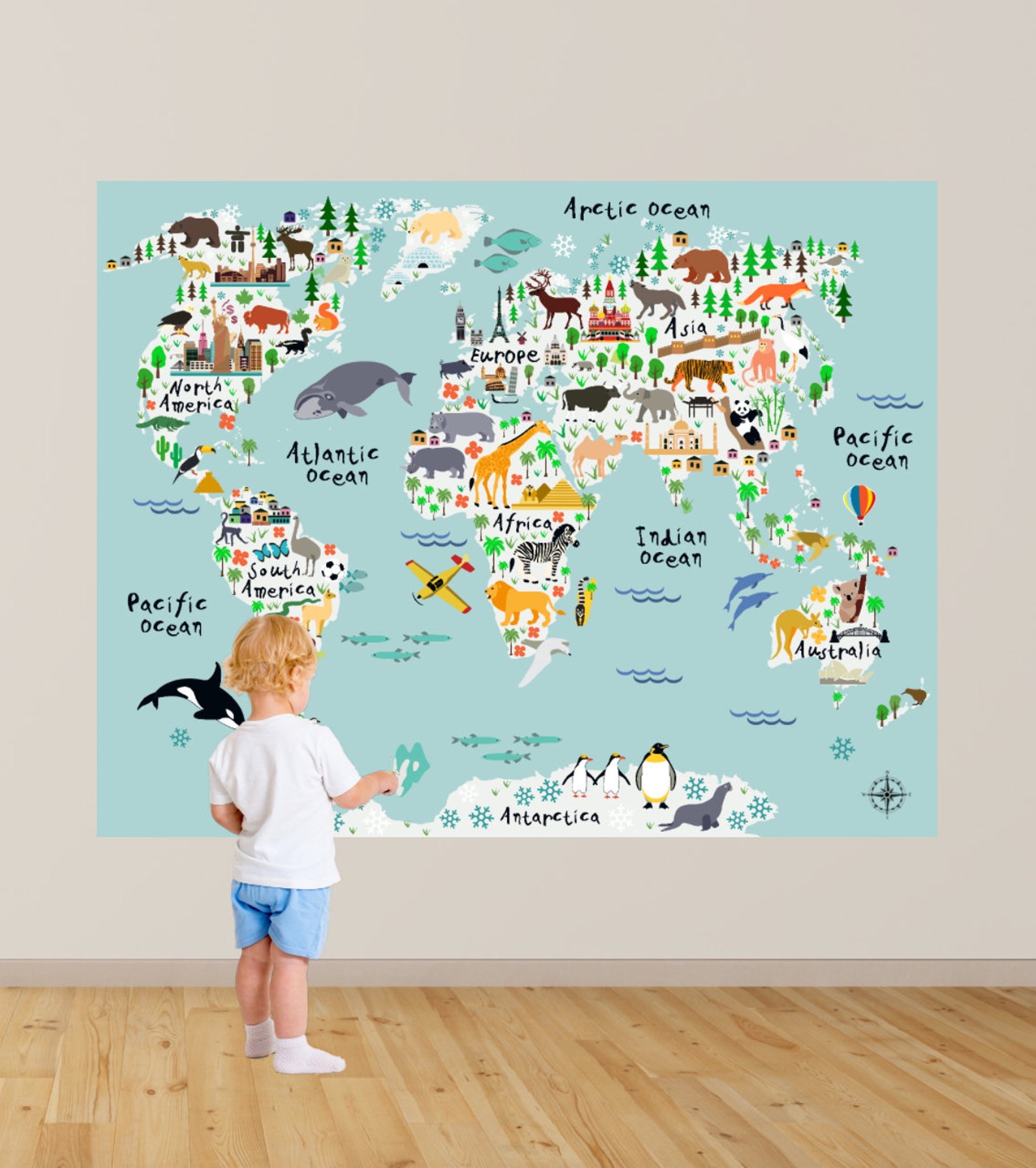 boy standing in front of map wall decal