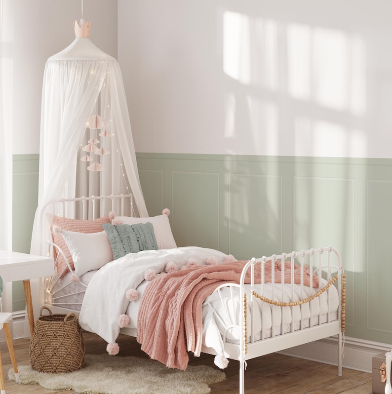 Puede incluir: Una cama con estructura de metal blanco con una manta rosa y blanca y un dosel blanco sobre la cama. La cama est&aacute; en una habitaci&oacute;n con paredes verdes y molduras blancas.
