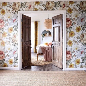 Puede incluir: Un dormitorio con papel tapiz floral, una cama con una manta rosa y una alfombra en el suelo. La habitaci&oacute;n tiene dos puertas de madera que conducen a otra habitaci&oacute;n.