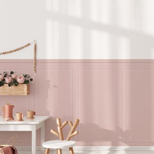 Puede incluir: Una silla de madera blanca con forma de ciervo con una pared rosa detrás. La pared tiene un diseño de panel con un borde blanco.