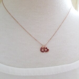 Puede incluir: Un delicado collar de oro rosa con dos peque&ntilde;os colgantes en forma de coraz&oacute;n. Cada colgante tiene una sola inicial grabada.