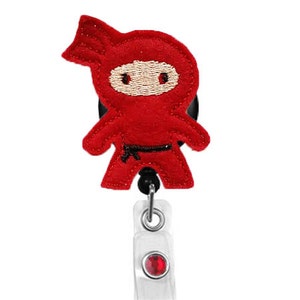 May include: Red felt ninja character badge reel with a black belt and a red rhinestone.