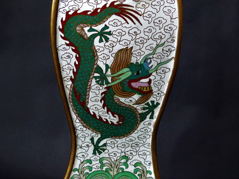 K&ouml;nnte beinhalten: Eine wei&szlig;e und goldene Cloisonn&eacute;-Vase mit einem gr&uuml;nen und roten Drachenmotiv. Der Drache ist von wei&szlig;en Wolken und gr&uuml;nen Wellen umgeben.