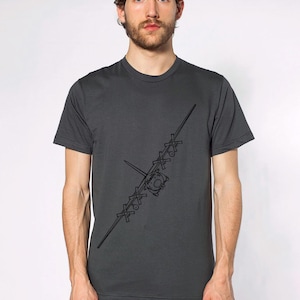 Puede incluir: Una camiseta gris antracita con un contorno negro de un avión en el lado izquierdo del pecho.