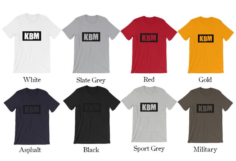 May include: A mockup of a t-shirt with the text "KBM" in a black box on the front. The t-shirt is shown in ten different colors: white, slate grey, red, gold, asphalt, black, sport grey, military, navy, and heather grey.