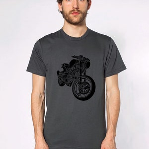 Op de afbeelding: Donkergrijs t-shirt met een zwarte motorfietsafbeelding. Het motorfietsontwerp is gedetailleerd en toont het voorwiel, het stuur en de motoronderdelen. Het shirt heeft een klassieke ronde hals.