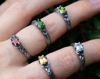 Anillo de plata de ley con turmalina verde y diseño de rama celta.