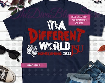 May include: A navy blue t-shirt with a white graphic that says "It's a Different World ISU Homecoming 2022". The graphic also includes a tiger head and a globe. The text is in a red, white, and black font.