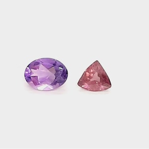May include: An oval-cut amethyst gemstone and a triangular pink tourmaline gemstone are displayed against a white background. The amethyst is a deep purple color, while the tourmaline is a vibrant pink.
