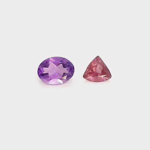May include: Two gemstones on a white background. One is an oval-cut amethyst with a star-like pattern, and the other is a triangular pink gemstone. The gemstones are likely for jewelry making.