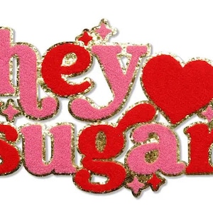 May include: A pink and red felt patch with gold glitter trim. The patch says "hey sugar" with a red heart in the middle.