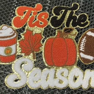 May include: A set of five felt patches with a fall theme. The patches are decorated with glitter and feature a pumpkin, a football, a coffee cup, a leaf, and the words "Tis the Season".