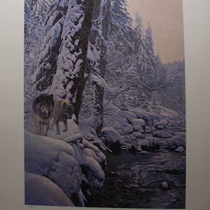 May include: A detailed print of a winter forest scene featuring two wolves. The artwork shows a snowy landscape with a river, snow-covered trees, and a soft colour palette. The wolves are in the foreground, adding a touch of wildlife to the serene setting.