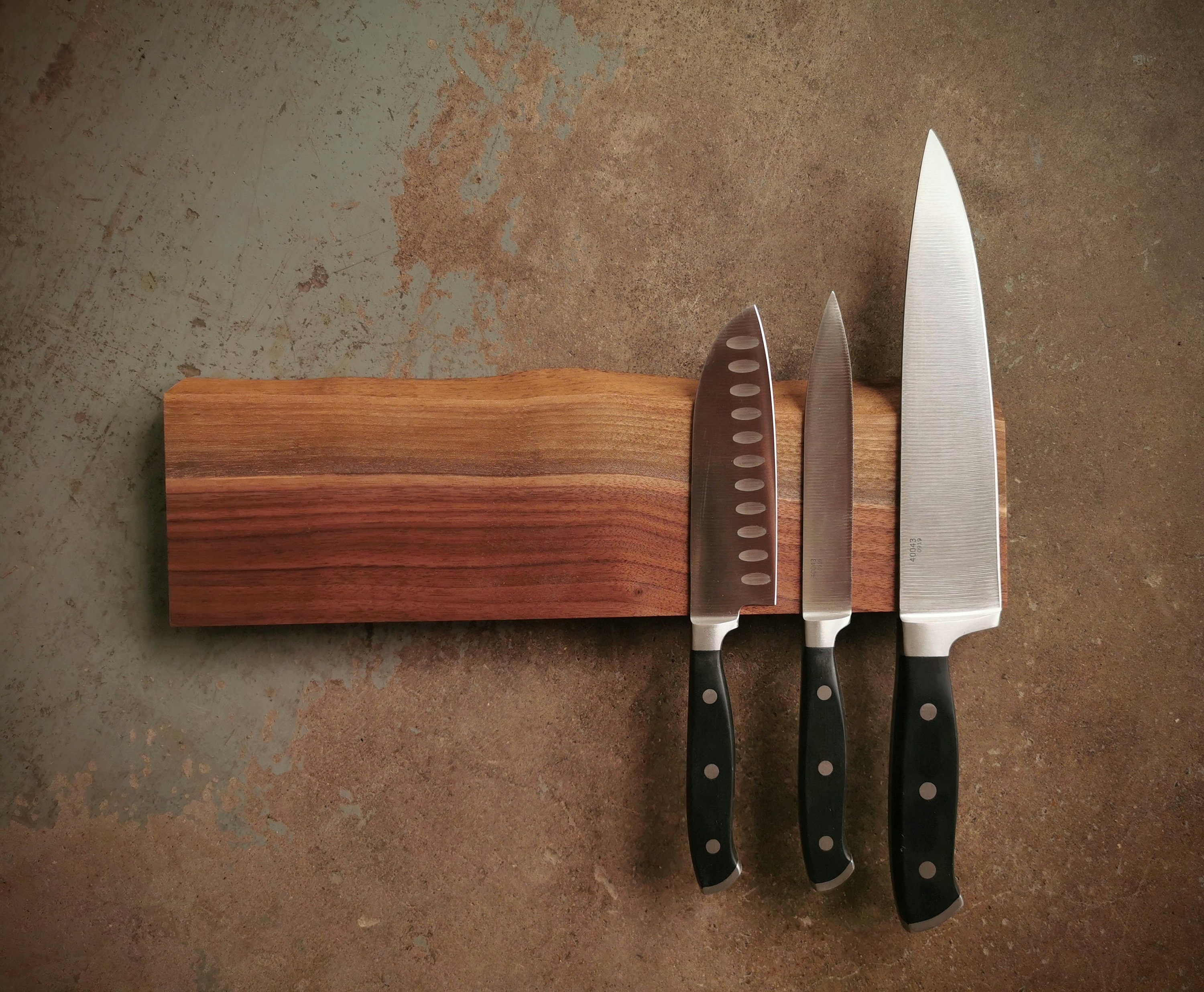 14 Inch Magnetic Live Edge Walnut Knife Holder Wooden Magnetic Knife three-knives-are-hanging-on-the-wall-next-to-jars