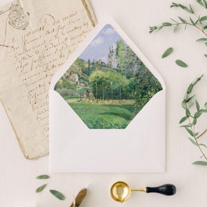 May include: A white envelope with a landscape painting visible inside. The painting depicts a green field, trees, and a small house under a blue sky. Beside the envelope is a vintage letter and decorative elements.