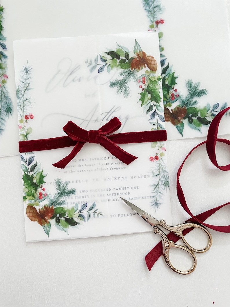 Greenery Holiday 5x7 vellum wrap jacket with evergreen wreath designs on the corner. The vellum jacket is wrapped around a 5x7 wedding invitation and meets in the middle.