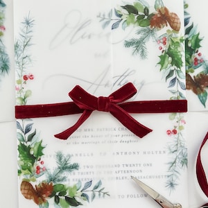 Christmas Holiday Invitation vellum jacket with Christmas designs on the corner. Vellum wrap is wrapped around a 5x7 invitation and meets in the middle. Evergreen printed designs for Christmas wedding or event invitations.