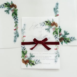 5x7 Christmas vellum jacket with wreath and evergreen designs on the corners. Vellum jacket is wrapped around a 5x7 invite and meets in the middle. Shown folded and flat.