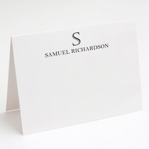 Può includere: Un biglietto bianco con testo nero che dice "S" e "SAMUEL RICHARDSON".