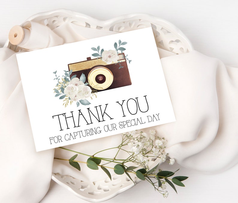 May include: A white thank you card with a vintage camera illustration and floral accents. The text reads "Thank You for capturing our special day."