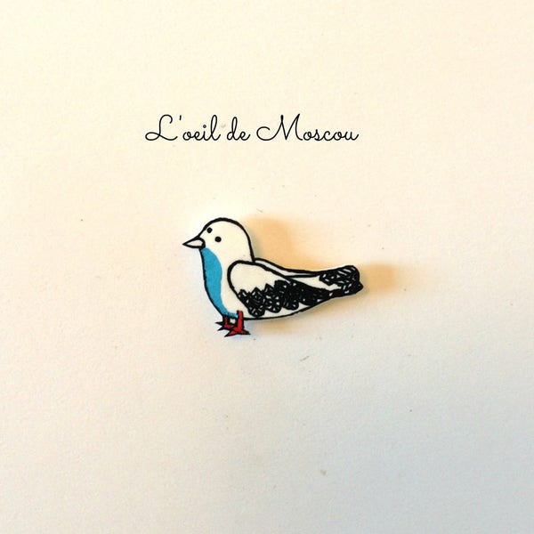 pin's oiseau blanc et bleu en plastique fou